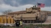 A US armored military vehicle drives on the outskirts of Rumaylan in Syria's northeastern Hasakeh province, bordering Turkey, on March 27, 2023.