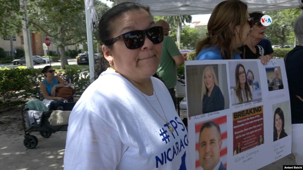 Bertha Sanles, que lleva indocumentada en Florida desde hace dos décadas, posa junto a un cartel con las fotografías de algunos legisladores estatales que aprobaron la ley SB 1718 contra la migración irregular. 