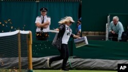 A Just Stop Oil protester runs onto Court 18 and releases confetti on day three of the Wimbledon tennis championships in London, July 5, 2023.