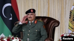 Le commandant militaire libyen Khalifa Haftar salue ses troupes lors des célébrations de la fête de l'indépendance à Benghazi, en Libye, le 24 décembre 2020.