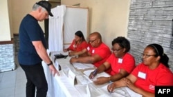 A handout picture released the Cuban website 'Cubadebate' shows Cuban President Miguel Diaz-Canel voting at a polling station in Santa Clara, Cuba, March 26, 2023, during the country's legislative election.
