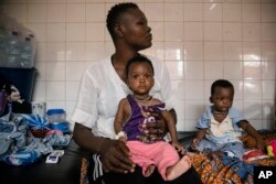 FILE - Malnourished children wait for treatment in the pediatrics department of Boulmiougou hospital in Ouagadougou, Burkina Faso, on April 15, 2022.