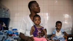 FILE — Malnourished children wait for medical treatment in Ouagadougou, Burkina Faso, April 15, 2022. In a new report, Care International says events in Africa are being underreported in the media as global attention shifts to conflicts in Europe and the Middle East.