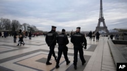 French gendarmes patrol the Trocadero plaza near the Eiffel Tower after a man targeted passersbys late Saturday, killing a German tourist with a knife and injuring two others in Paris, Dec. 3, 2023.