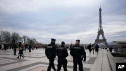 Polisi Prancis berpatroli di alun-alun Trocadero dekat Menara Eiffel setelah seorang pria menewaskan seorang turis Jerman dengan pisau dan melukai dua lainnya di Paris, Minggu, 3 Desember 2023. (AP/Christophe Ena)