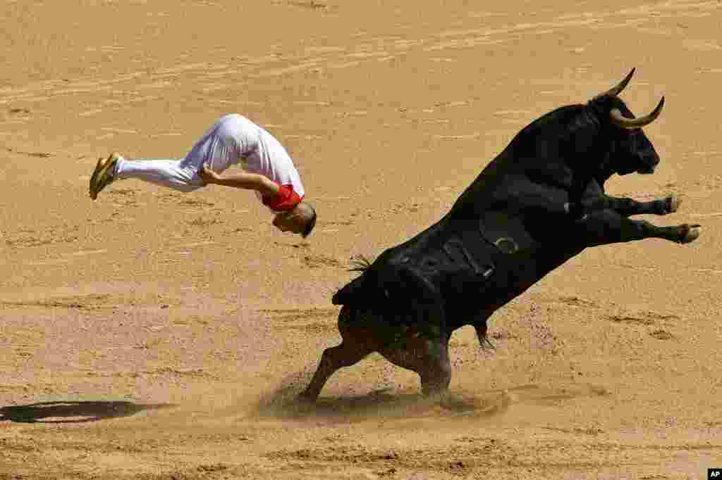 A &#39;&#39;Recortador&#39;&#39; jumps over a bull in the bull ring during the Recortadores festival at the San Fermin fiestas in Pamplona, northern Spain.
