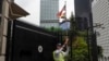 Seorang penjaga keamanan berdiri di luar Konsulat Jenderal Amerika Serikat setelah dirusak dengan grafiti di Hong Kong, Selasa, 13 Juni 2023. (AP/Louise Delmotte)US Graffiti