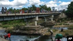 FILE - People bathe in the Massacre River on the border with Haiti in Ouanaminthe, Dominican Republic, Nov. 19, 2021. The Dominican Republic's President Luis Abinader announced on Sept. 11, 2023, that he has suspended issuing visas to Haitians. 