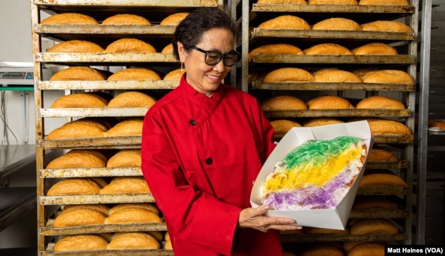 FILE: Huong Tran, owner of Dong Phuong Bakery, shows her popular king cake during Mardi Gras 2021 at the bakery in New Orleans.