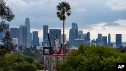 Low clouds gather over the Los Angeles skyline seen from Elysian Park ahead of forecasted rain in Los Angeles, Feb. 18, 2024. 