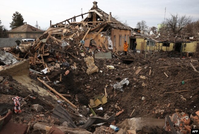 A local resident looks at a crater following a Russian missile attack in Chuhuyiv, Kharkiv region, Ukraine, on Feb. 15, 2024.