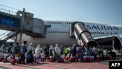 FILE - Jemaah Haji Indonesia menaiki pesawat penumpang di Bandara Internasional Juanda Sidoarjo, sebelum bertolak ke Mekah, 24 Mei 2023. (JUNI KRISWANTO / AFP)