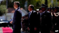 Cyprus' President Nikos Christodoulides, second left, and Greek Prime Minister Kyriakos Mitsotakis, left, review a military guard of honor before their meeting at the Presidential Palace in Nicosia, Cyprus, July 31, 2023.
