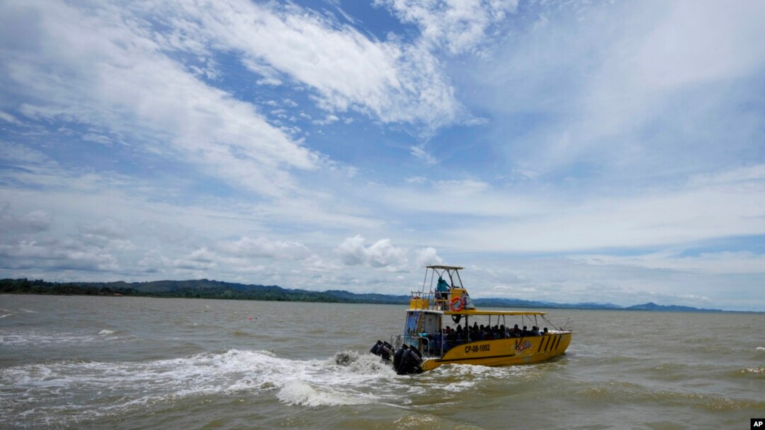 ARCHIVO - Un barco transporta a migrantes a Acandí, cerca de la frontera con Panamá, cuando salen de Necoclí, Colombia, el lunes 13 de septiembre de 2021.