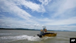 ARCHIVO - Un barco transporta a migrantes a Acandí, cerca de la frontera con Panamá, cuando salen de Necoclí, Colombia, el lunes 13 de septiembre de 2021.