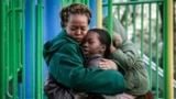 Derry Oliver, 17, right, hugs her mother, also Derry Oliver, during a visit to a playground near home, Friday, Feb. 9, 2024, in New York. 