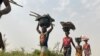 Des femmes et des enfants reviennent de leurs terres agricoles après une journée de travail dans le village d'Agatu au Nigeria, le 5 janvier 2022.