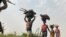 Des femmes et des enfants reviennent de leurs terres agricoles après une journée de travail dans le village d'Agatu au Nigeria, le 5 janvier 2022.