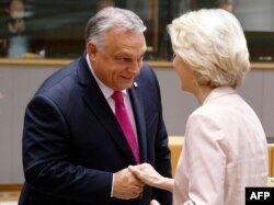 FILE - Hungary's Prime Minister Viktor Orban (L) shakes hands with President of the European Commission Ursula von der Leyen prior to the start of EU leaders Summit at The European Council Building in Brussels, Oct. 26, 2023.