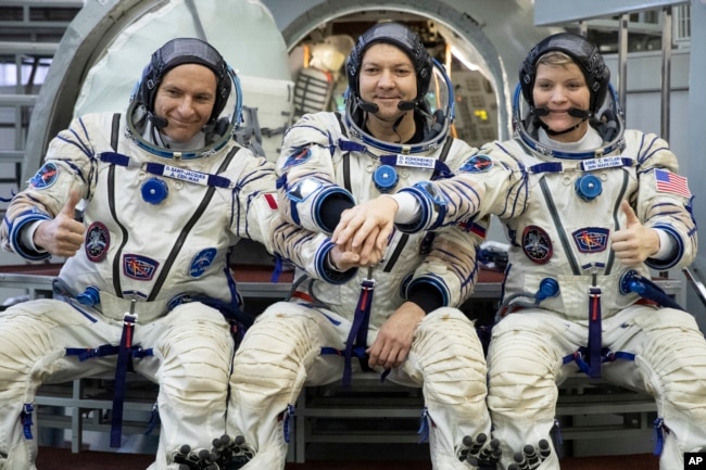 FILE - From left, CSA astronaut David Saint Jacques, Russian cosmonaut Оleg Kononenko‎, and U.S. astronaut Anne McClain pose for a photo before preflight examinations on Wednesday, Nov. 14, 2018. (AP Photo/Pavel Golovkin, File)