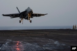 A fighter jet lands on the USS Dwight D. Eisenhower in the Red Sea, June 11, 2024.