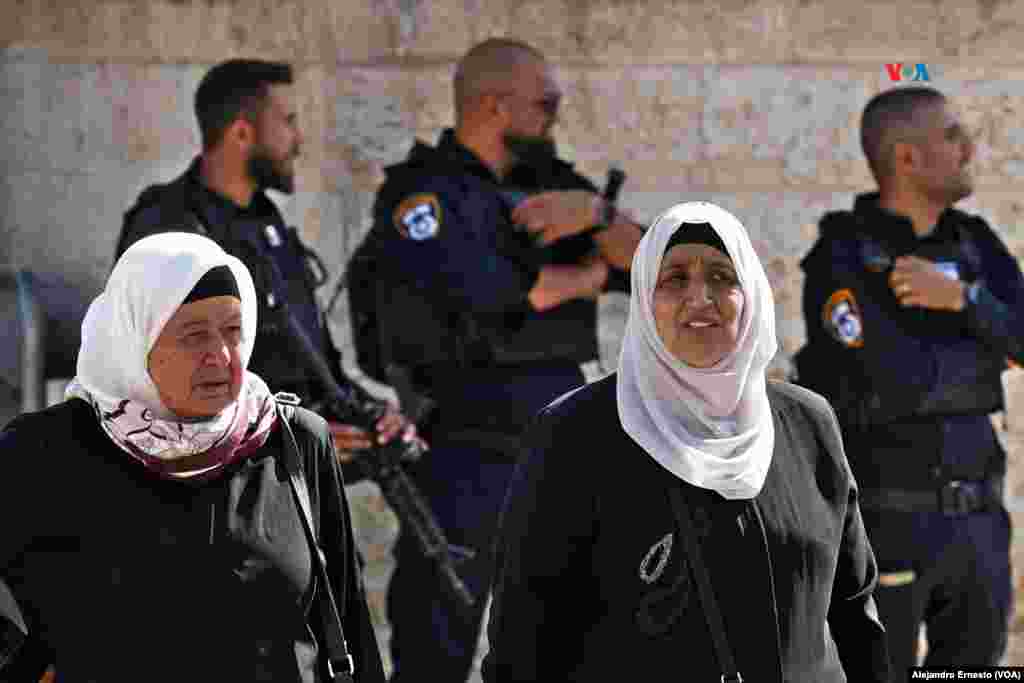 Dos mujeres palestinas caminan por uno de los accesos a la Ciudad Vieja de Jerusalén, fuertemente custodiada hoy viernes, principal día de oración para loa musulmanes.