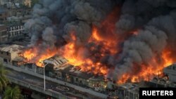 আকাশ থেকে তোলা এই ছবিতে দেখা যাচ্ছে, ঢাকার বঙ্গবাজার মার্কেটে অগ্নিকাণ্ডের পর আগুন নেভানোর চেষ্টা করছে অগ্নিনির্বাপক কর্মীরা। ৪ এপ্রিল, ২০২৩। (ফাইল ছবি) 