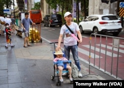 People wear hats and carry hand-made fans to cool down from the extreme heat in Bangkok, Thailand, April 23, 2023.