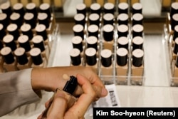 Lee Young-jin, divisi Pengembangan Produk Sesuai Pesanan AmorePacific, menganalisis warna kulit menggunakan teknologi AI untuk merekomendasikan warna alas bedak yang optimal, Seoul, Korea Selatan, 7 Juni 2024. (Foto: REUTERS/Kim Soo-hyeon)