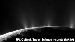 The icy crust at the south pole of Enceladus exhibits large fissures that allow water from the subsurface ocean to spray into space as geysers, forming a plume of icy particles. NASA’s Cassini spacecraft captured this imagery in 2009.