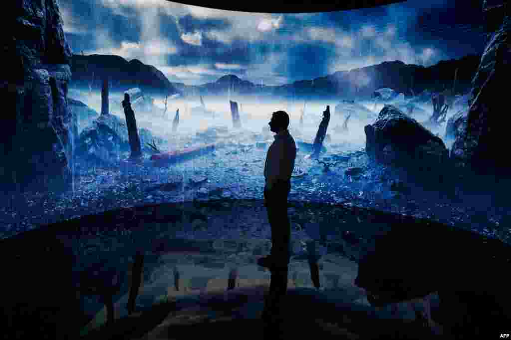 A man looks at a digital display at an exhibition by the Andrey Melnichenko Foundation during the COP28 United Nations climate summit in Dubai. (Photo by Ludovic MARIN / AFP)