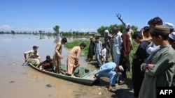 Warga yang mengungsi tiba dengan perahu melintasi daerah banjir setelah hujan lebat di distrik Nowshera, provinsi Khyber-Pakhtunkhwa, Pakistan Selasa, 16 April 2024.