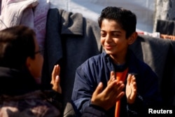 Displaced Palestinian teenager Hussam Al-Attar, nicknamed by people 'Newton', gestures at a tent camp in Rafah, in the southern Gaza Strip, February 6, 2024. (REUTERS/Ibraheem Abu Mustafa)
