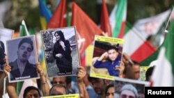 이란 경찰에 구금된 중에 사망한 마흐사 아미니 씨 사망 1주기를 맞아 벨기에 브뤼셀에서 사람들이 아미니 씨 사진을 들고 시위하고 있다 (자료사진) 