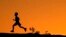 La silueta de un niño se recorta contra el cielo al atardecer mientras corre a lo largo de una cresta en Papago Park, el viernes 1 de abril de 2022, en Phoenix. (Foto AP/Charlie Riedel)