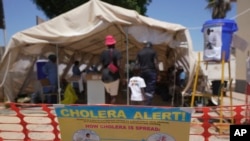 FILE - A family enters a tent set aside for cholera patients at a clinic in Harare, Zimbabwe, on Nov. 18, 2023. 