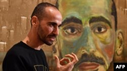 Artist Mostafa Azimitabar is pictured in front of his work, titled 'Self-Portrait,' as the finalists' work for the Archibald Prize is displayed in Sydney on May 5, 2022. 