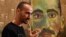 Artist Mostafa Azimitabar is pictured in front of his work, titled 'Self-Portrait,' as the finalists' work for the Archibald Prize is displayed in Sydney on May 5, 2022. 