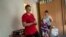 Nataliia Skakun, former resident of Oleshky, Ukraine, stands next to her daughter Anastasia and grandson Maxim at their apartments in Mykolaiv, Ukraine, Tuesday, July 4, 2023.