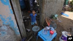 Un niño, en la entrada de su casa, dañada por el paso del devastador huracán Otis por la ciudad de Acapulco, México, el 26 de octubre de 2023.