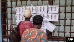 Des électeurs vérifient leurs noms sur la liste électorale au lycée Boganda de Bangui, le 30 juillet 2023.