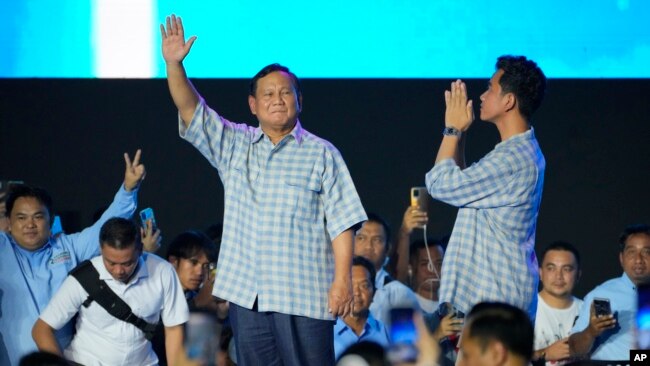 Indonesian presidential candidate Prabowo Subianto, left, and his running mate Gibran Rakabuming Raka, the eldest son of Indonesian President Joko Widodo, greet supporters during a gathering in Jakarta, Feb. 14, 2024.