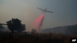 A plane uses retardant to put out a fire in Safed, Israel, June 12, 2024. Scores of rockets were fired from Lebanon toward northern Israel June 12, and Hezbollah said it had launched rockets and weaponized drones at nine Israeli military sites June 13.