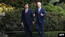 FILE - Chinese President Xi Jinping, left, and U.S. President Joe Biden walk together at Filoli Estate during their meeting in Woodside, California, Nov. 15, 2023.