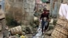 FILE - A boy walks past sewage around houses in Abuja, Nigeria, Sept. 3, 2021. Nigerian authorities have declared a national emergency and activated response operations to control the spread of a cholera outbreak that has killed more than 50 people. 