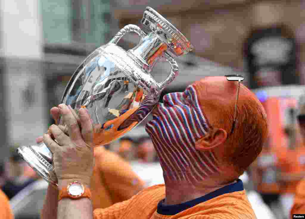 A fan of Netherlands kisses a Euro trophy replica ahead of the UEFA Euro 2024 semi-final football match between the Netherlands and England during the in Dortmund, Germany.