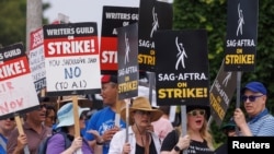 Para aktor yang tergabung dalam SAG-AFTRA dan penulis dalam "Writers Guild of America" melakukan aksi mogok di depan Paramount Studios di Los Angeles, California, 17 Juli 2023.