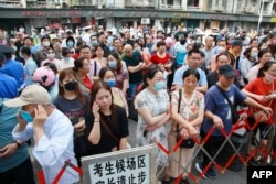 Parents wait outside a school as students arrive to sit the National College Entrance Examination (NCEE) in Nanjing, in China's eastern Jiangsu province, June 7, 2023.