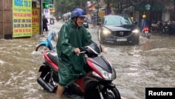 A man drives a motorbike in a flooded street after heavy rains in Hanoi, Vietnam, Sept. 28, 2023.