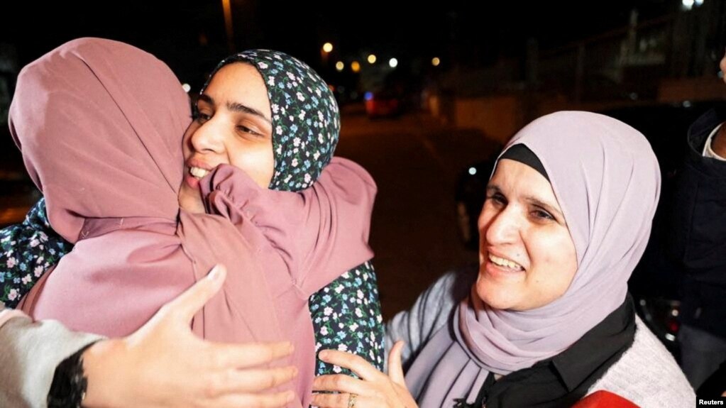 2023年11月24日，在耶路撒冷，哈马斯和以色列交换人质囚犯后，获释的巴勒斯坦囚犯玛拉·布克尔在她家附近与家人能打招呼。（路透社照片）